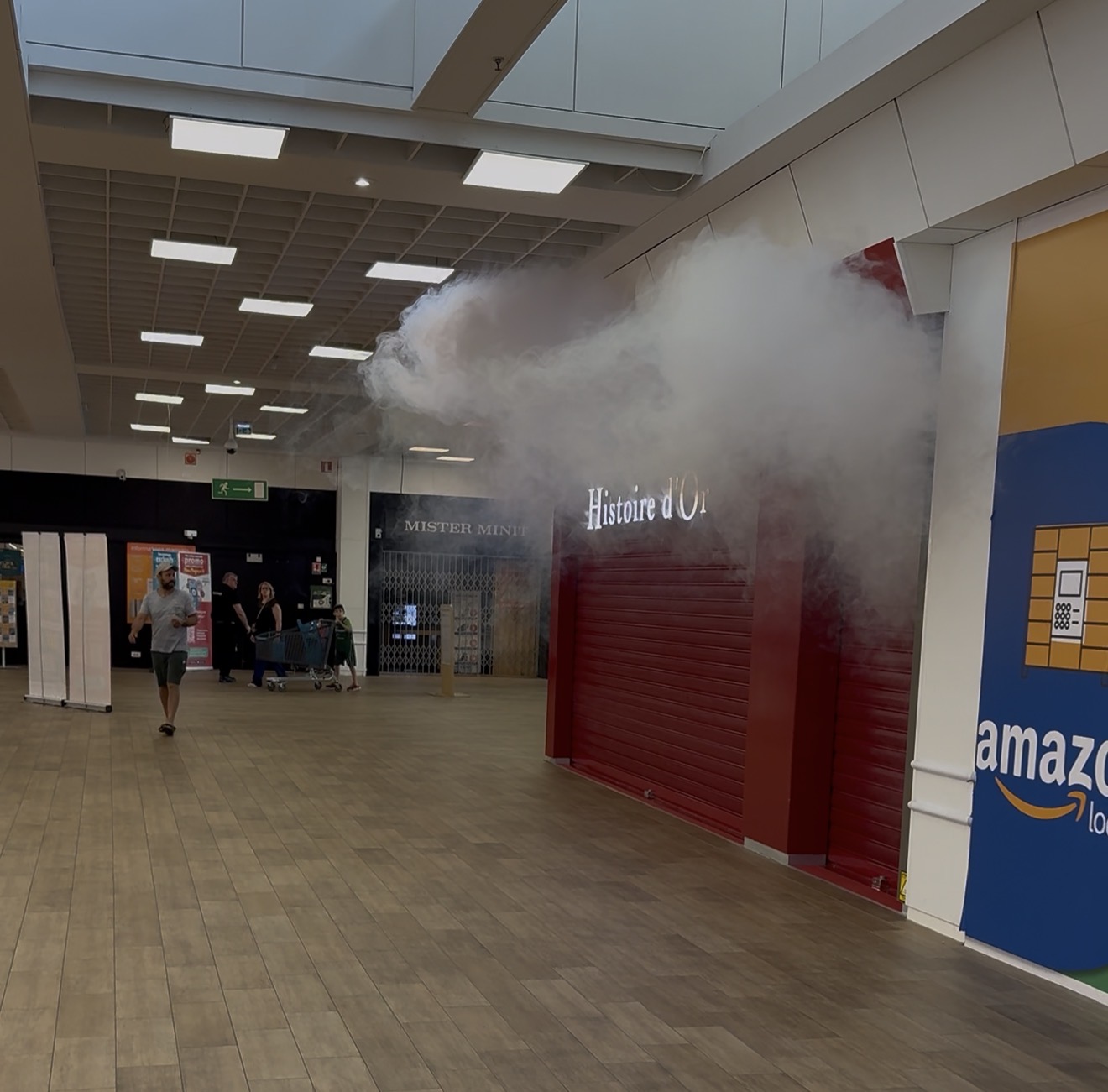 UNE FUMÉE ÉPAISSE SE DÉGAGE DE LA GALERIE MARCHANDE D’HYPER U.